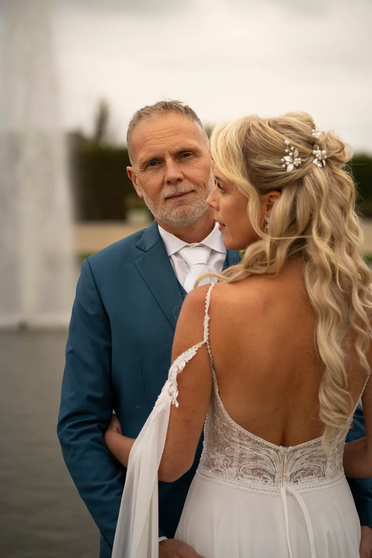 Remco kijkt in de camera, Inge kijkt naar hem, bij het water