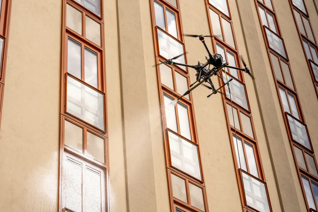 Drone van DroneWash Nederland reinigt de ramen van een hoge gevel
