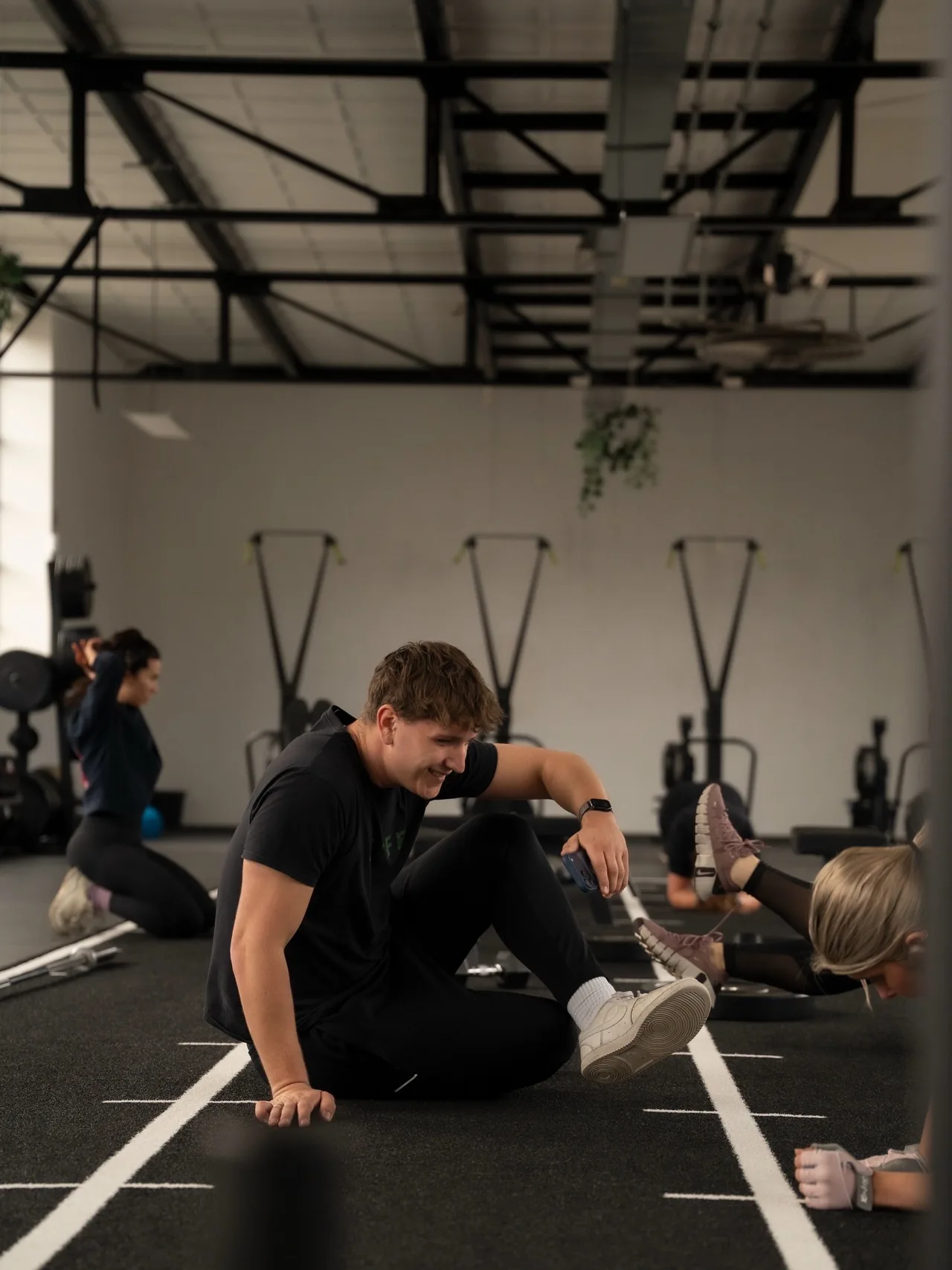 Een sporter rekt zich uit op de vloer bij FitLife