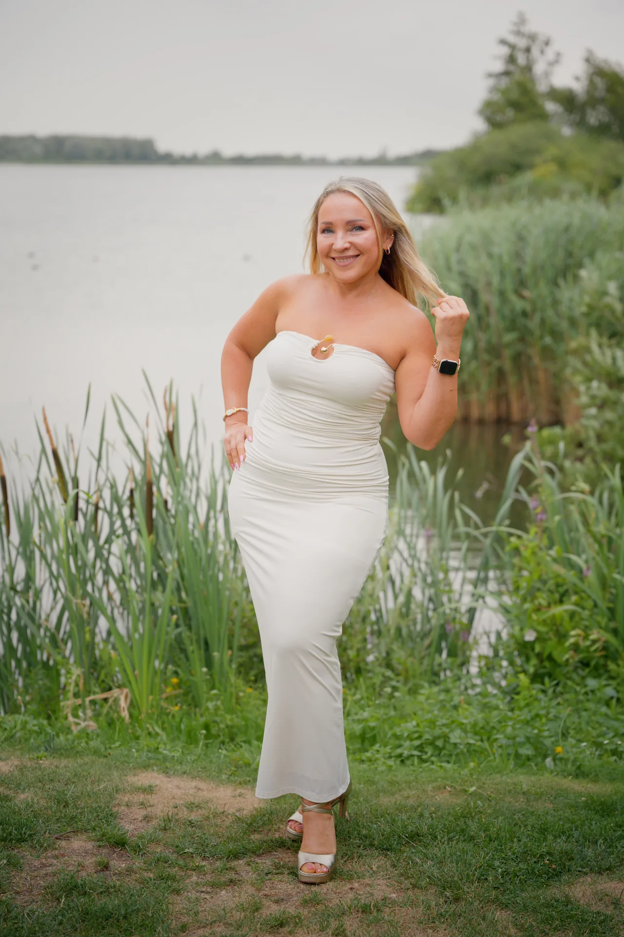 Gast in een witte jurk lacht op de FitLife-borrel