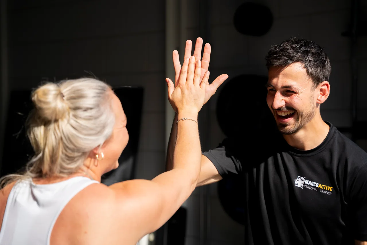 Een sporter en de coach geven elkaar een high five
