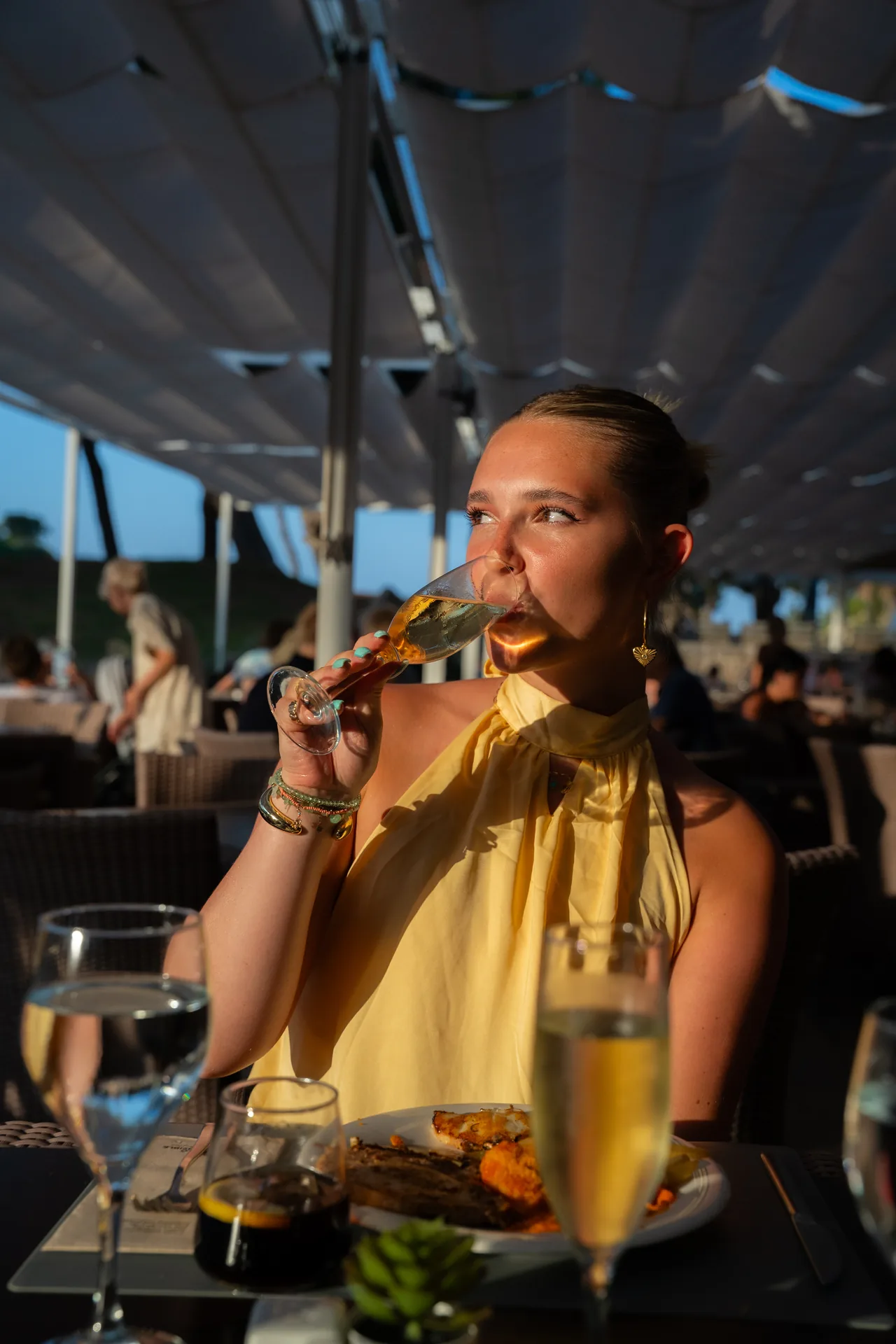 Een vrouw neemt een slok op een zonnig terras op Mallorca